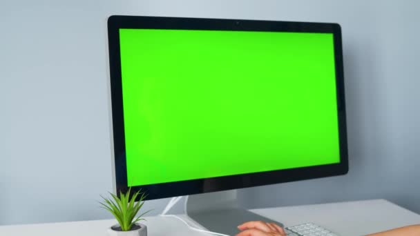 Donna che digita su una tastiera del computer, monitor con uno schermo verde. Chiave cromatica. Copia spazio. — Video Stock