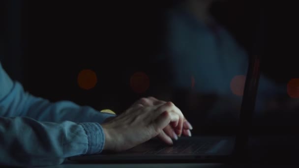 Vrouwelijke handen typt op een laptop 's nachts — Stockvideo