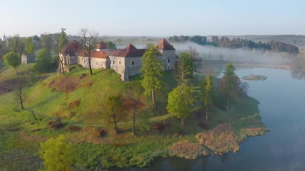 Letecký pohled na hrad Svirzh u Lvova, Ukrajina za úsvitu. Jezero, ranní mlha a okolní krajina při východu slunce. Zrychlené video — Stock video