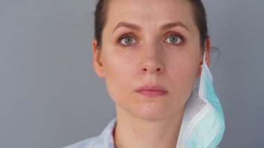 Covid-19 koronavirüsünün pandemik koruması. Tıbbi maske takan beyaz bir kadın. Virüs koruması.