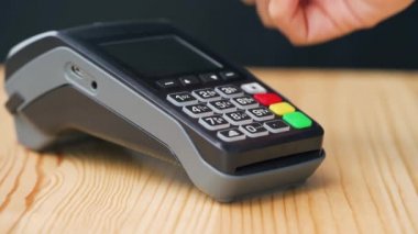 NFC kredi kartı ödemesi. NFC teknolojisiyle kredi kartıyla ödeme yapan bir kadın. Kablosuz para transferi. Kablosuz ödeme
