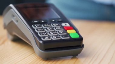 Akıllı telefonunla temassız ödeme. Kablosuz ödeme konsepti. Yakın plan, kadın banka terminalindeki siparişi ödemek için akıllı telefon nakitsiz cüzdan teknolojisi kullanıyor..