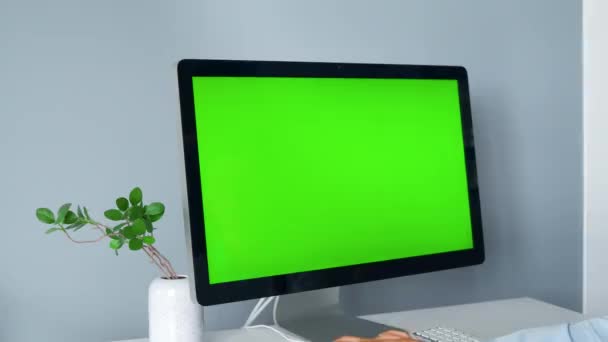 Mujer escribiendo en un teclado de ordenador, monitor con una pantalla verde. Clave de croma. Copiar espacio. — Vídeos de Stock