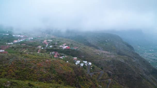 Superficie de la isla de Tenerife - pueblo de montaña, carretera, nubes bajas. Islas Canarias, España. Cronograma aéreo — Vídeos de Stock