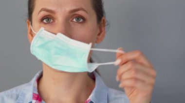 Covid-19 koronavirüsünün pandemik koruması. Tıbbi maske takan beyaz bir kadın. Virüs koruması.