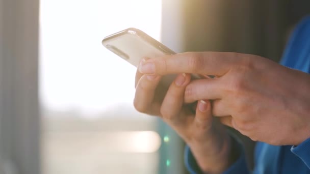 Manos femeninas usando smartphone contra el sol poniente. — Vídeos de Stock