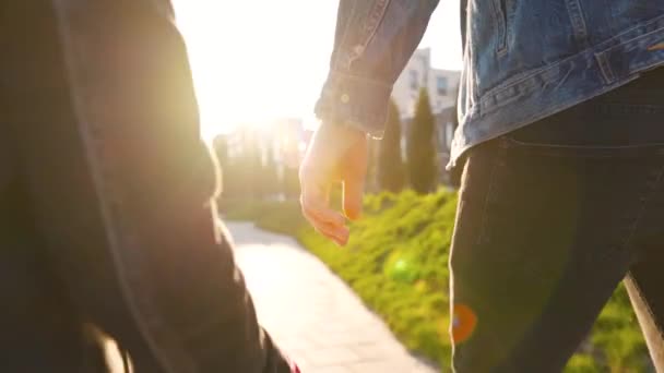 Pappa och dotter går runt i sitt område vid solnedgången. Barnet håller fadern i handen. — Stockvideo