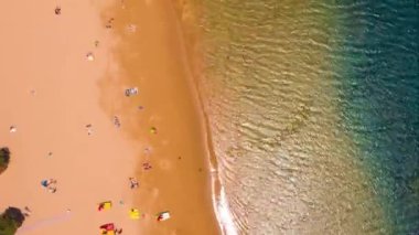 Altın kumun yüksekliğinden, palmiye ağaçlarından, güneş pansiyonlarından, plajdaki tanınmayan insanlardan, otoparktaki arabalardan manzara. Tenerife, Kanaryalar, İspanya. Hiperlapse