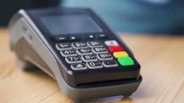 Akıllı telefondan yapılan temassız ödeme. Kablosuz ödeme konsepti. Yakın plan, kadın banka terminalindeki siparişi ödemek için akıllı telefon nakitsiz cüzdan teknolojisi kullanıyor..
