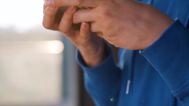 Ženské ruce pomocí smartphonu proti zapadajícímu slunci. — Stock video