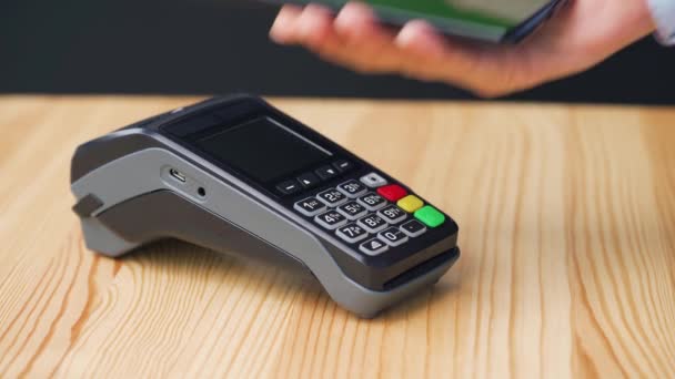 Kontaktlös betalning med smartphone med grön mock-up skärm. Koncept för trådlös betalning. Närbild, kvinna som använder smartphone kontantlös plånbok NFC-teknik för att betala order på bank terminal. — Stockvideo