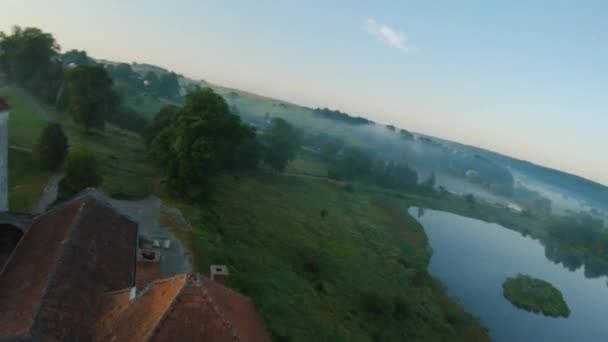 Barevné horkovzdušné balóny létají nad středověkým hradem a jezerem v ranní mlze. Manévrovatelné letové a energetické smyčky. Cestování, dobrodružství, festival. — Stock video