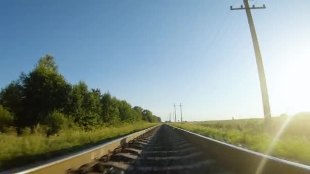 FPV drönare flygning snabbt och nära järnvägsspår i en klar solig dag — Stockvideo