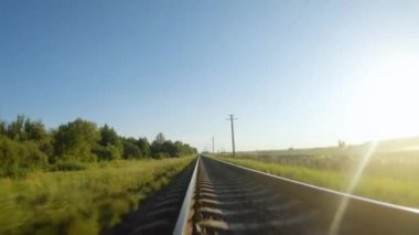 Güneşli bir günde tren raylarına yakın hızlı uçuş.