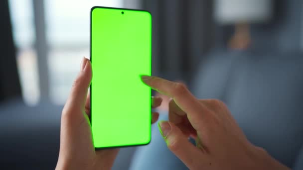 Vrouw thuis liggend op een bank en met behulp van smartphone met groene mock-up scherm in verticale modus. Meisje surfen op internet, kijken naar inhoud, video 's, blogs. POV. — Stockvideo