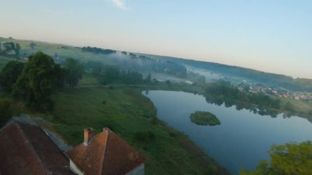 Barevné horkovzdušné balóny létají nad středověkým hradem a jezerem v ranní mlze. Manévrovatelný let. Cestování, dobrodružství, festival. — Stock video