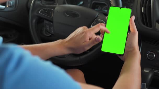 Водій, який використовує смартфон всередині автомобіля. Смартфон Chromakey з зеленим екраном. Автоматична навігація. Інтернет залежність — стокове відео