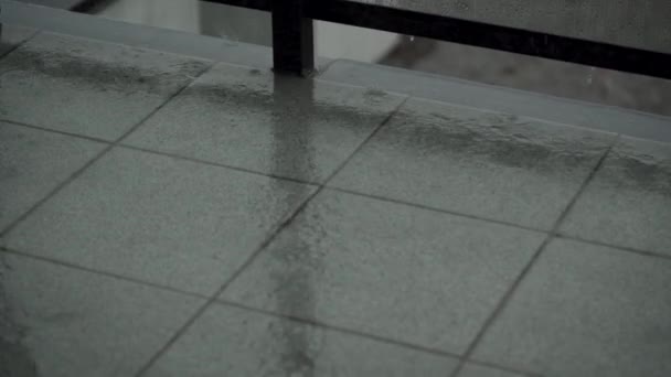 Zware regenval giet het balkon of terras. druppels lopen door het glas van het hek — Stockvideo