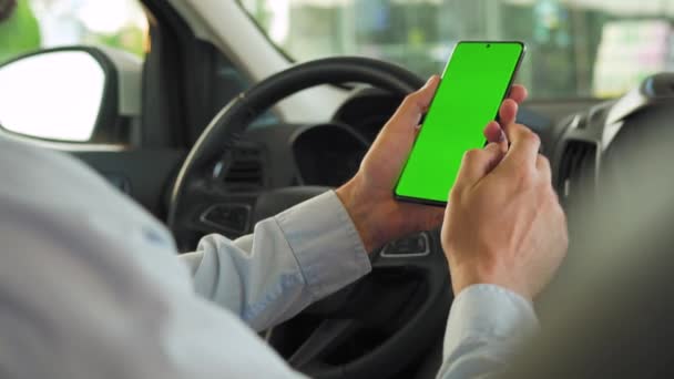Chauffeur utilisant un smartphone à l'intérieur de la voiture. Smartphone Chromakey avec écran vert. Navigation automatique. Dépendance à Internet — Video