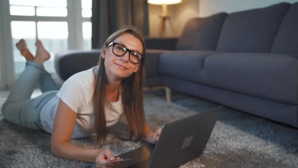 Kobieta leży na podłodze i dokonuje zakupu online za pomocą karty kredytowej i laptopa. Zakupy online, technologia stylu życia — Wideo stockowe