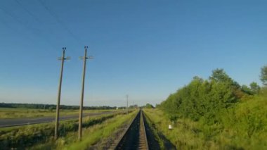 Demiryolu boyunca uçuyor, arabaların gittiği yolun yanında.