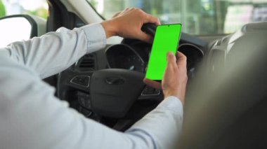 Sürücü arabanın içinde akıllı telefon kullanıyor. Yeşil ekranlı Chromakey akıllı telefon. Otomatik navigasyon. İnternet bağımlılığı