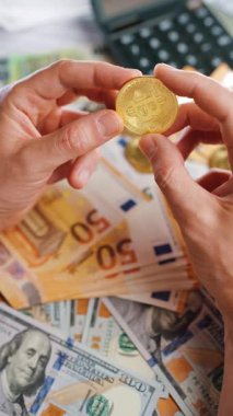 Erkek eli, farklı para birimlerinin -dolar ve avro- arka planında BTC bitcoin gösteriyor. Kripto para birimi kavramı ve engelleme teknolojisinin geniş dünyası..