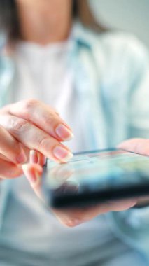 Sosyal medyada akıllı telefondan yayın yapan, dokunmatik ekranlara dokunan, kurye uygulaması kullanan bir kadın. Elinde cep telefonu olan bir kadın. Dikey video