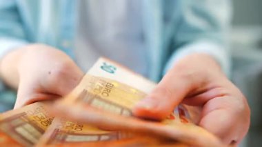 Avro banknotlarını sayan bir kadın, yakın plan. Yatırım, başarı, finansal beklentiler veya kariyer ilerlemesi kavramı.