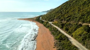 Yumuşak dalgalar ve yemyeşil yeşilliklerle dolu sakin bir sahilin havadan görünüşü. Korfu adası kıyıları, Yunanistan