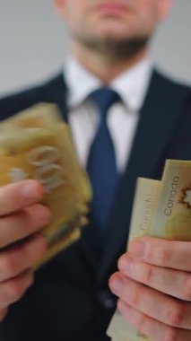 Resmi olarak giyinmiş adam Kanada Doları 'nı sayıyor, yakın plan. Yatırım, başarı, finansal beklentiler veya kariyer ilerlemesi kavramı. 
