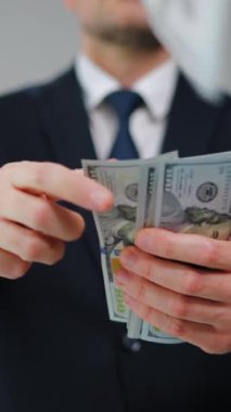 Resmi olarak giyinmiş bir adam Amerikan Doları 'nı kameraya doğru savuruyor. Yatırım, başarı, finansal beklentiler veya kariyer gelişimi kavramı. Yavaş çekim