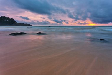 Plajda kasvetli tropik gün batımı. Tayland 