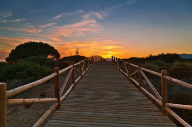 Ahşap yolu günbatımı zaman içinde deniz kenarında. Mijas Costa. Andalusia. İspanya