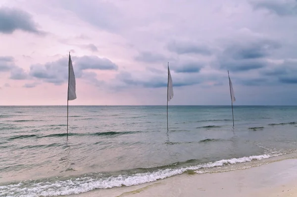 海の白い旗とビーチで悲観的な熱帯の夕日 — ストック写真