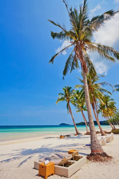 Beautiful tropical beach with  lounges and palms under blue sky at Phu Quoc island  in Vietnam.