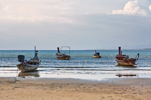 Traditional Thai boats near the beach at sunset time. Nai Yang beach. Phuket. Thailand