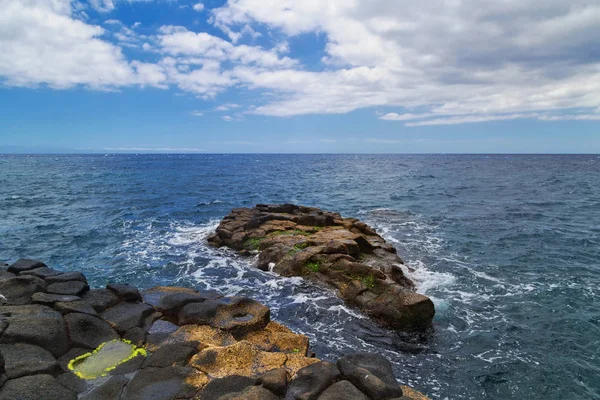 Svart stonesl stranden under blå himmel — Stockfoto