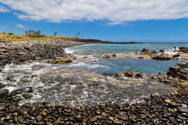 Siyah stonesl plaj mavi gökyüzü altında — Stok fotoğraf