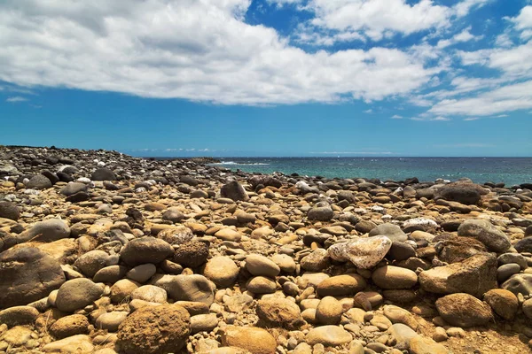 Siyah stonesl plaj mavi gökyüzü altında — Stok fotoğraf