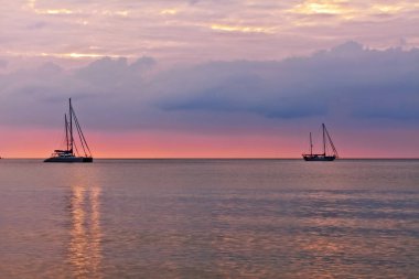 Deniz gün batımında yatlar 