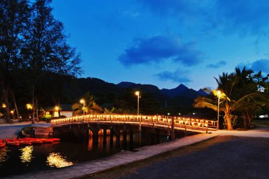 Geceleri küçük bir nehir boyunca fenerler ile Köprü