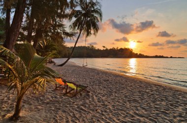 Gün batımında sahilde şezlong chaises