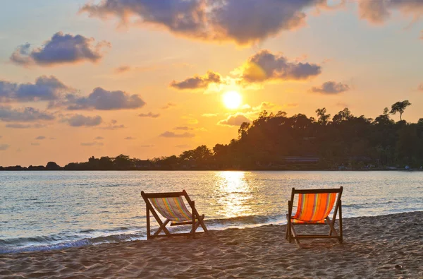 Gün batımında sahilde şezlong chaises — Stok fotoğraf