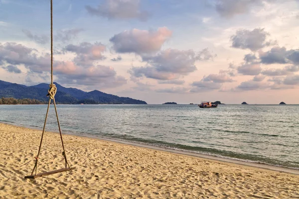 海滩上的一棵树上挂着木制秋千，夕阳西下 — 图库照片