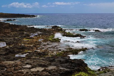 Mavi gökyüzünün altında taşlarla güzel deniz