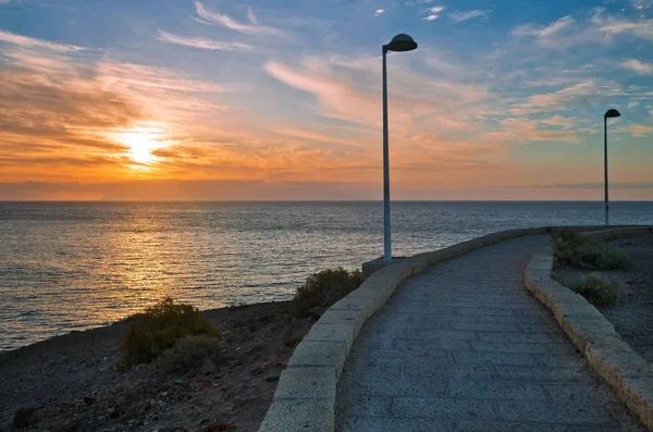 Stenen stoep langs de zee bij zonsondergang — Stockfoto