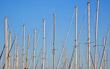 Mavi gökyüzü arka planda arma ile beyaz tekne ve yat direkleri