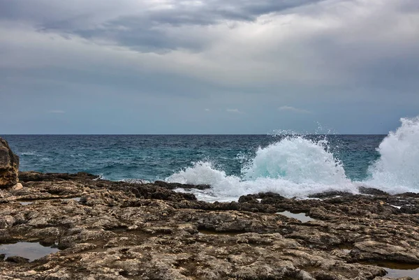 Praia rochosa sob um céu dramático sombrio — Fotografia de Stock