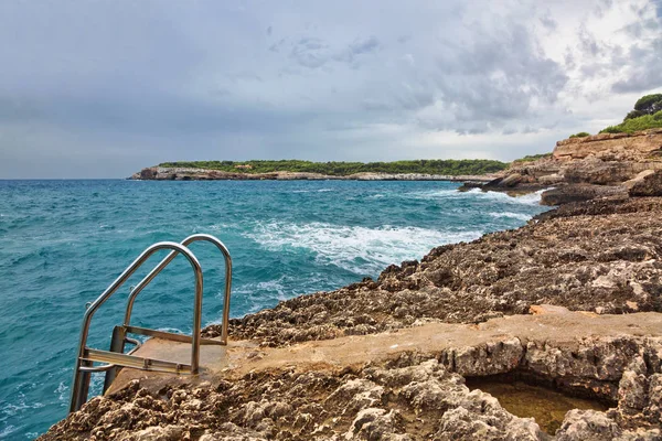 Rotsachtig strand onder een sombere dramatische hemel — Stockfoto